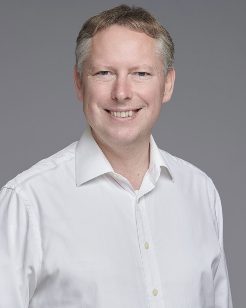 Professional business headshot of a CEO, photographed in a London studio with a neutral backdrop. Crispin Beale