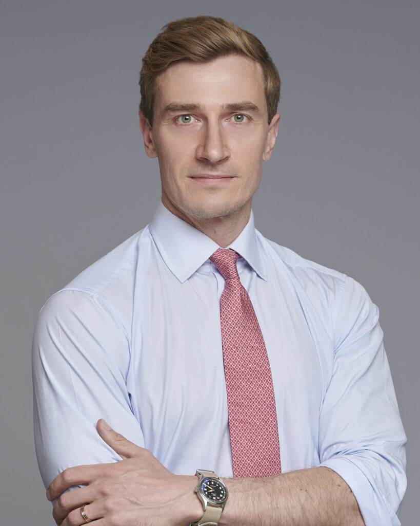 Professional business headshot of a man in a suit, photographed in London with a neutral backdrop.