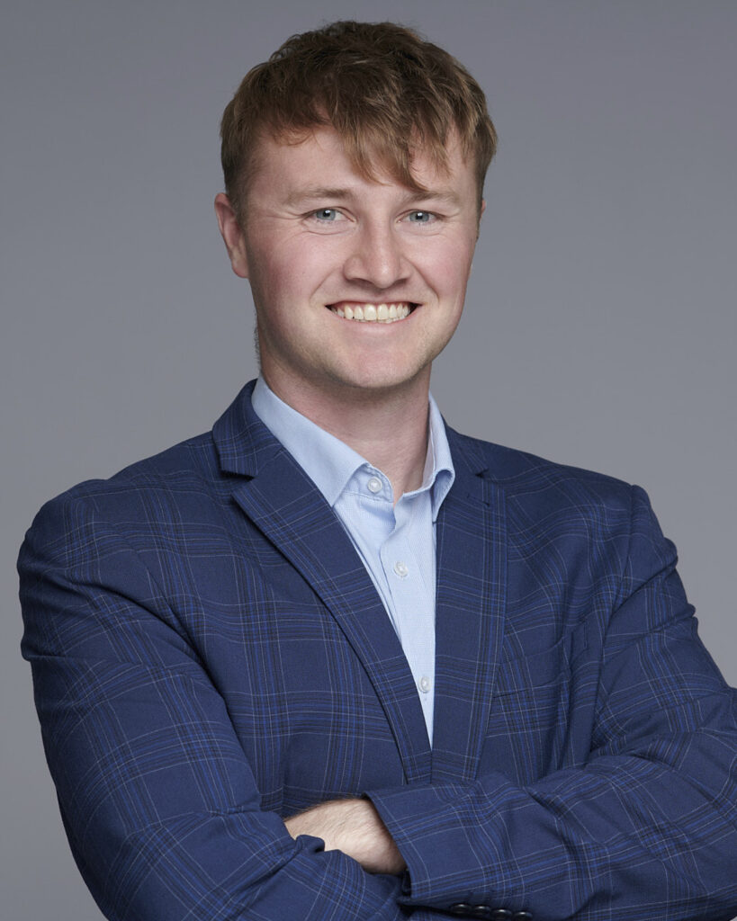 Professional business headshot of a man in a suit, photographed in London with a neutral backdrop.