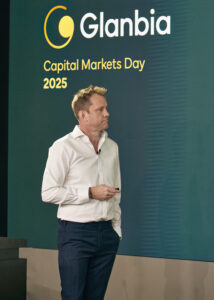Male presenter in a white shirt and blue trousers speaking on stage at the Glanbia Capital Markets Day 2025 event